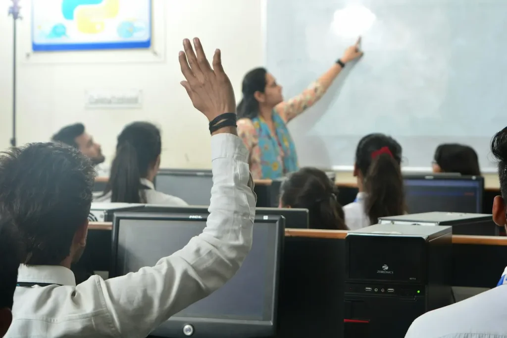 A Student Raising His Hand in a Computer Lesson 