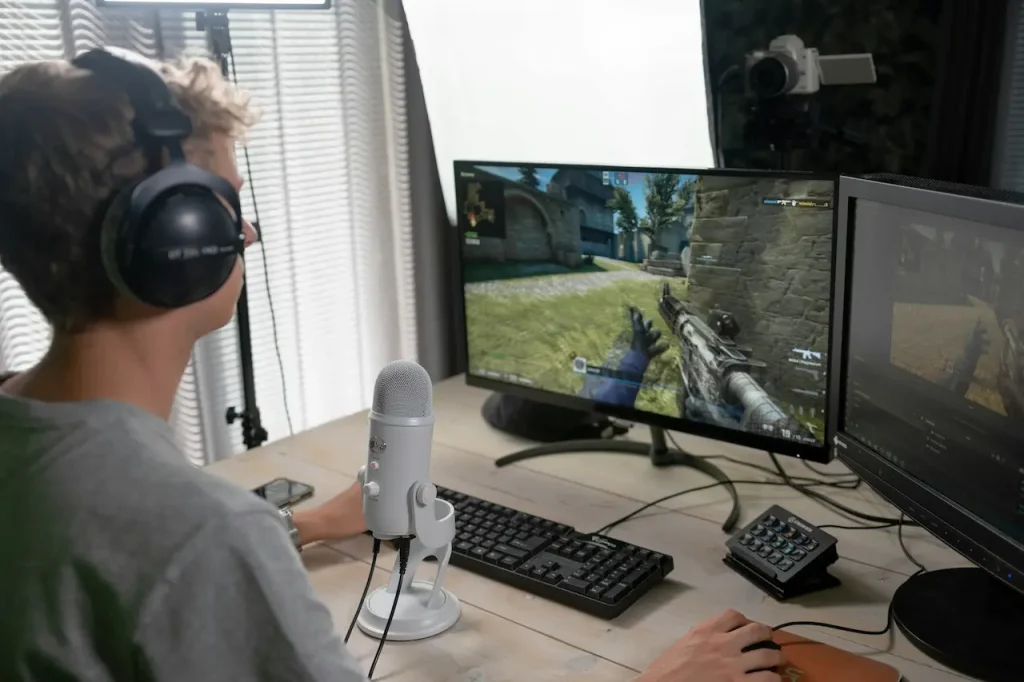 A Man Playing a First-Person Shooter Game on His PC 