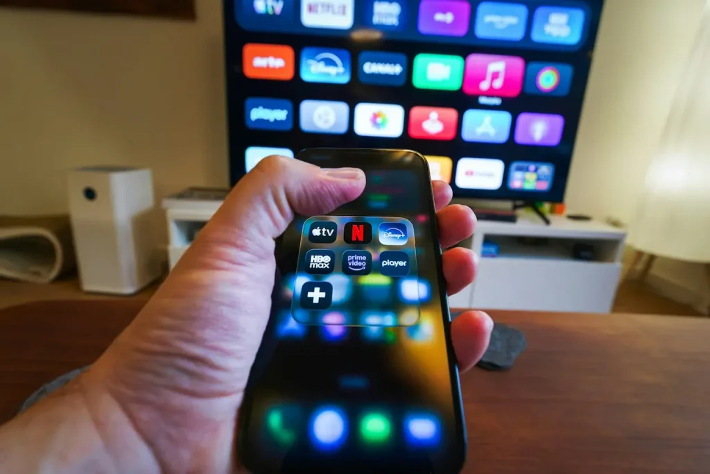 A Person Using a Smartphone as a Remote to Control their Apple TV