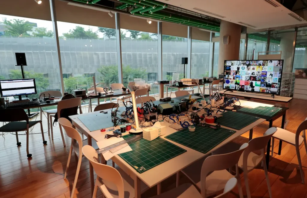 A Table Filled with a Soldering Machine and a Self-Healing Cutting Mat 
