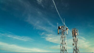 Black metal telecommunications tower under blue sky