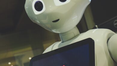 White robot toy holding a black tablet