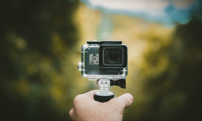 Person holding an action camera outdoors