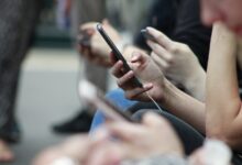 Teenager holding a smartphone showing a social media app