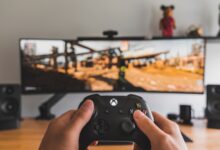 Person holding a game controller for cloud gaming