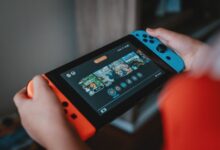 Handheld gaming console being held outdoors