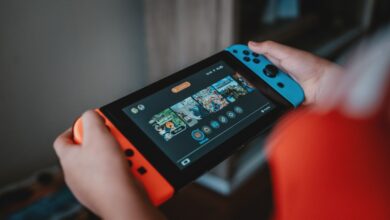 Handheld gaming console being held outdoors
