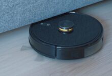 Black robot vacuum cleaner on a wooden floor