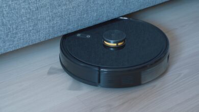 Black robot vacuum cleaner on a wooden floor