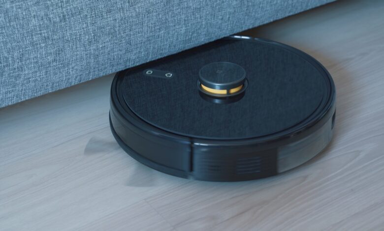 Black robot vacuum cleaner on a wooden floor