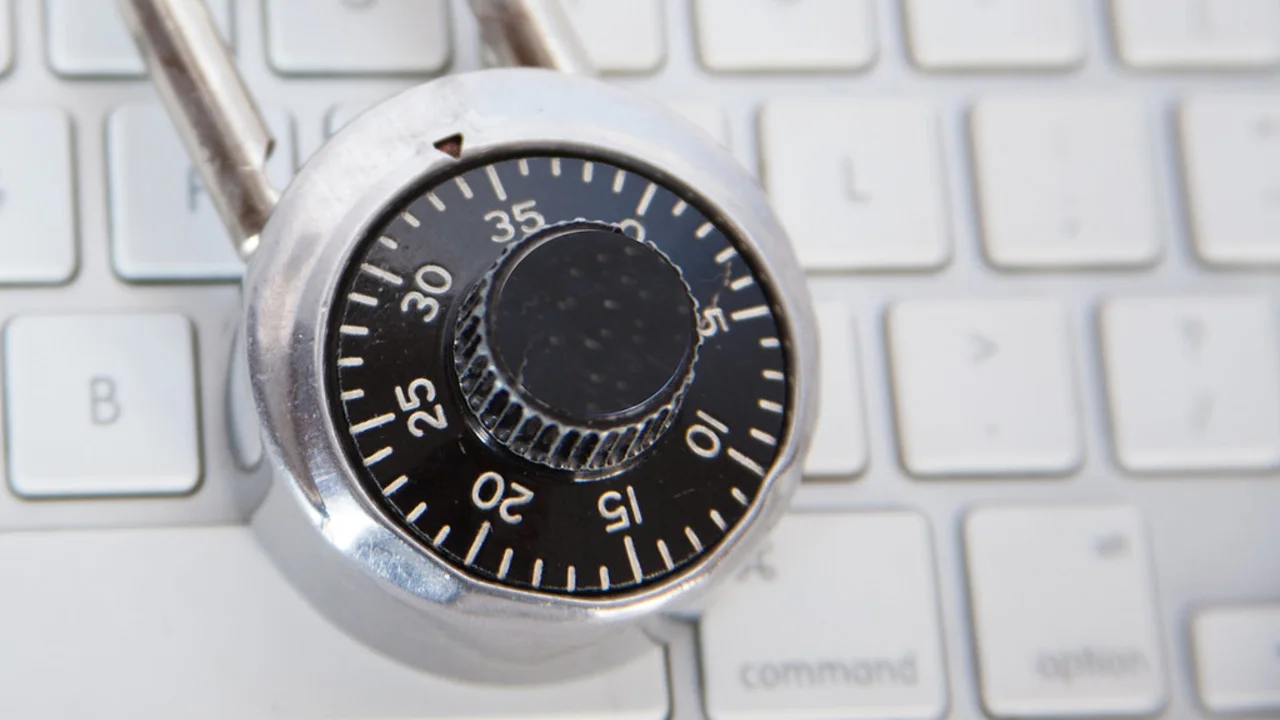 A combination padlock resting on a computer keyboard, symbolising account login security