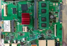 Close-up of a laptop motherboard with RAM modules and a red heatsink, showing the kind of internal components involved in a device repair