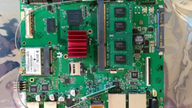 Close-up of a laptop motherboard with RAM modules and a red heatsink, showing the kind of internal components involved in a device repair