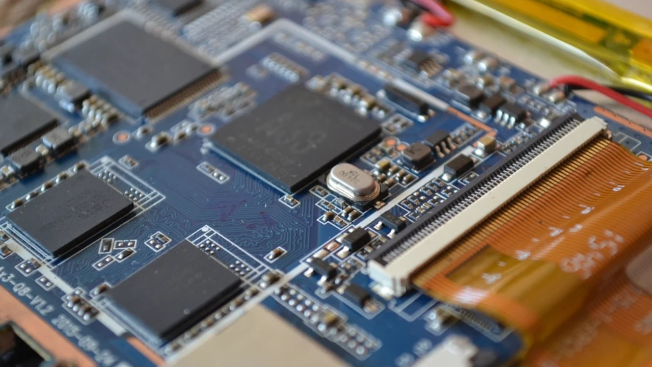 Macro shot of a blue phone circuit board with a ribbon cable connector exposed during a repair