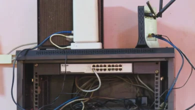 A home network rack with a router, switch and patch cables mounted on a wall