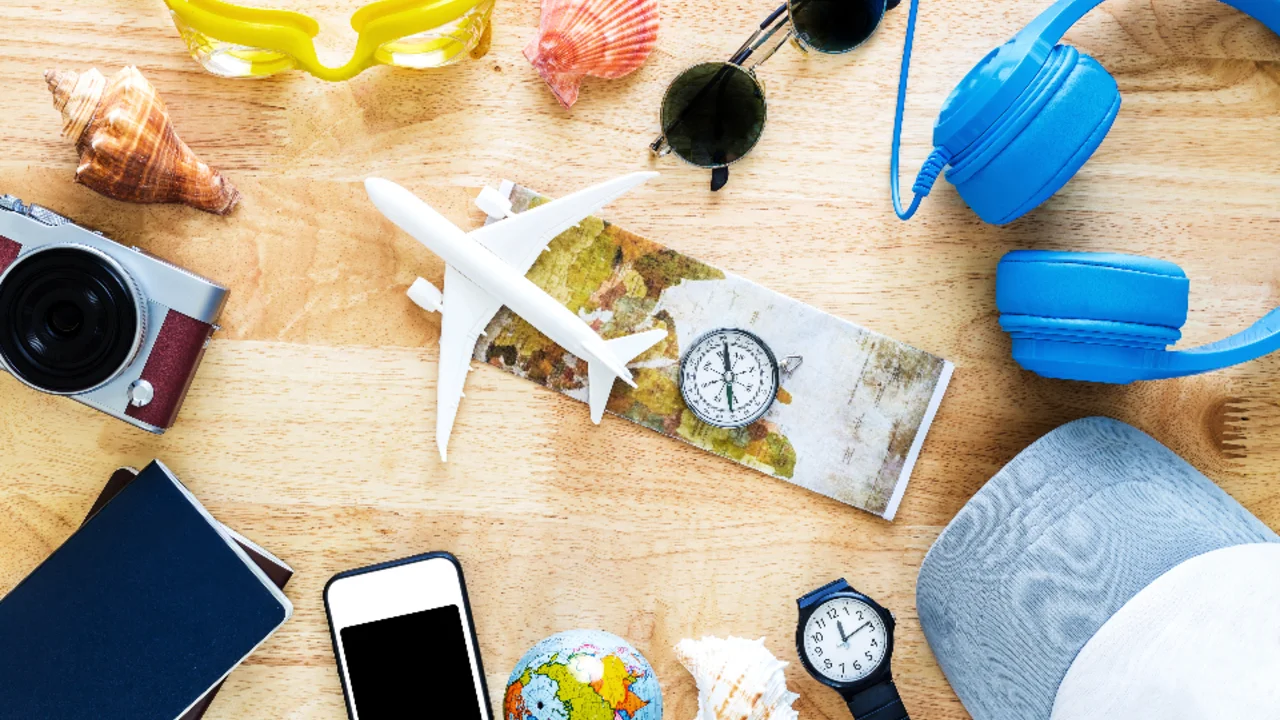 A passport, phone and portable charger laid out on a table ready for overseas travel