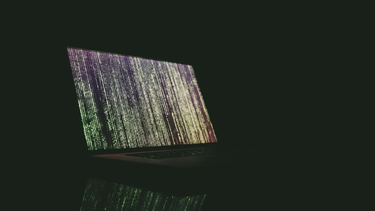 Close-up of a keyboard and monitor showing open source software code being edited